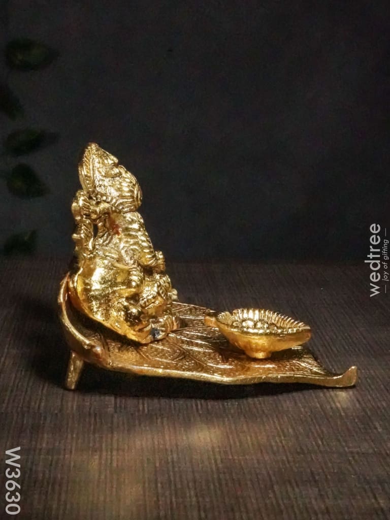 White Metal Ganesha In Pipal Leaf With Diya Gold Finish - W3630 Diyas